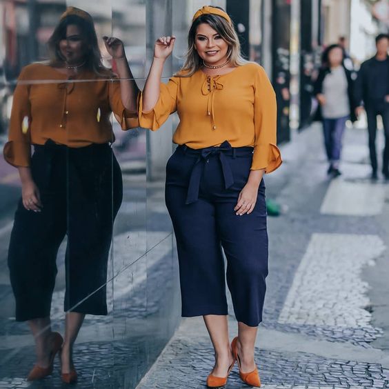 Look plus size com pantacout azul clássico e blusa mostarda. 